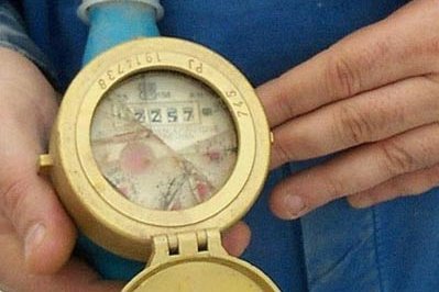 Bild: Ein Monteur zeigt einen Wasserzähler mit Frostschaden